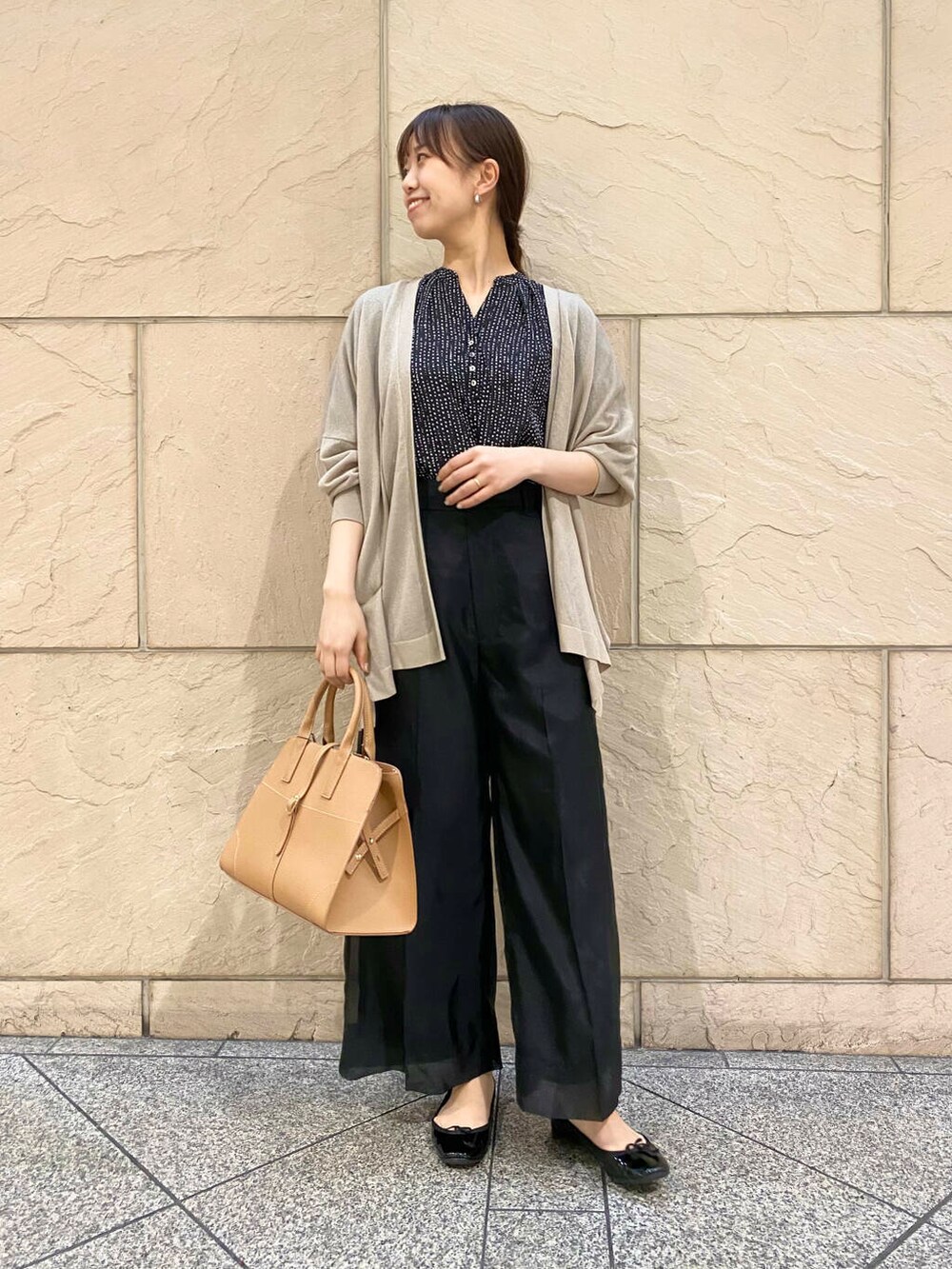 ブラック系のその他パンツ、イエロー系のトートバッグ、ベージュ系のカーディガン/ボレロを着用したレディースの春コーディネートの2枚目の写真