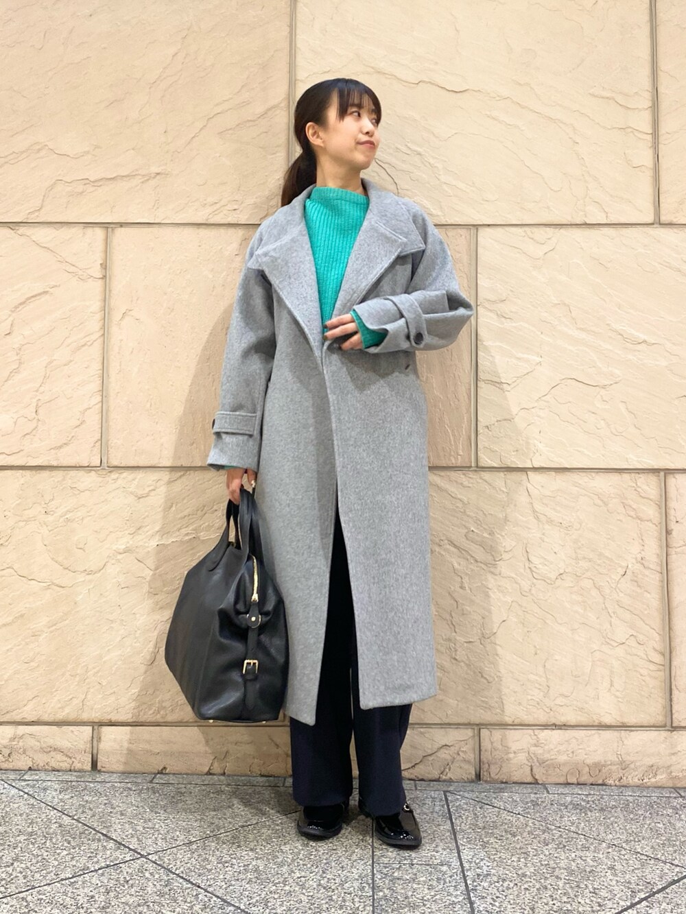 グレー系のその他アウター、グリーン系のニット/セーター、ブルー系のその他パンツを着用したレディースの冬コーディネートの3枚目の写真