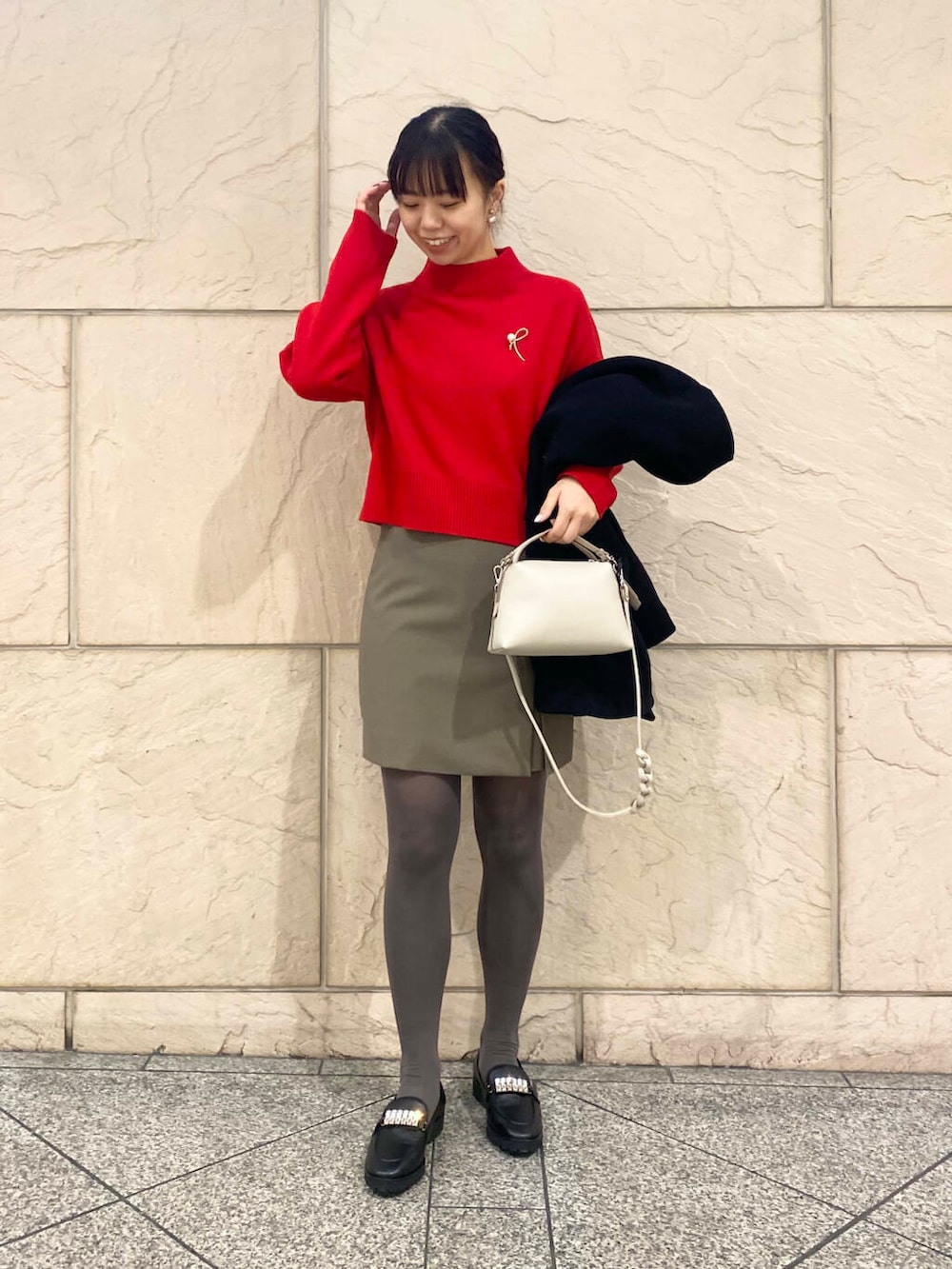 ブラック系のその他アウター、ブラウン系のスカート、レッド系のニット/セーターを着用したレディースの冬コーディネートの4枚目の写真
