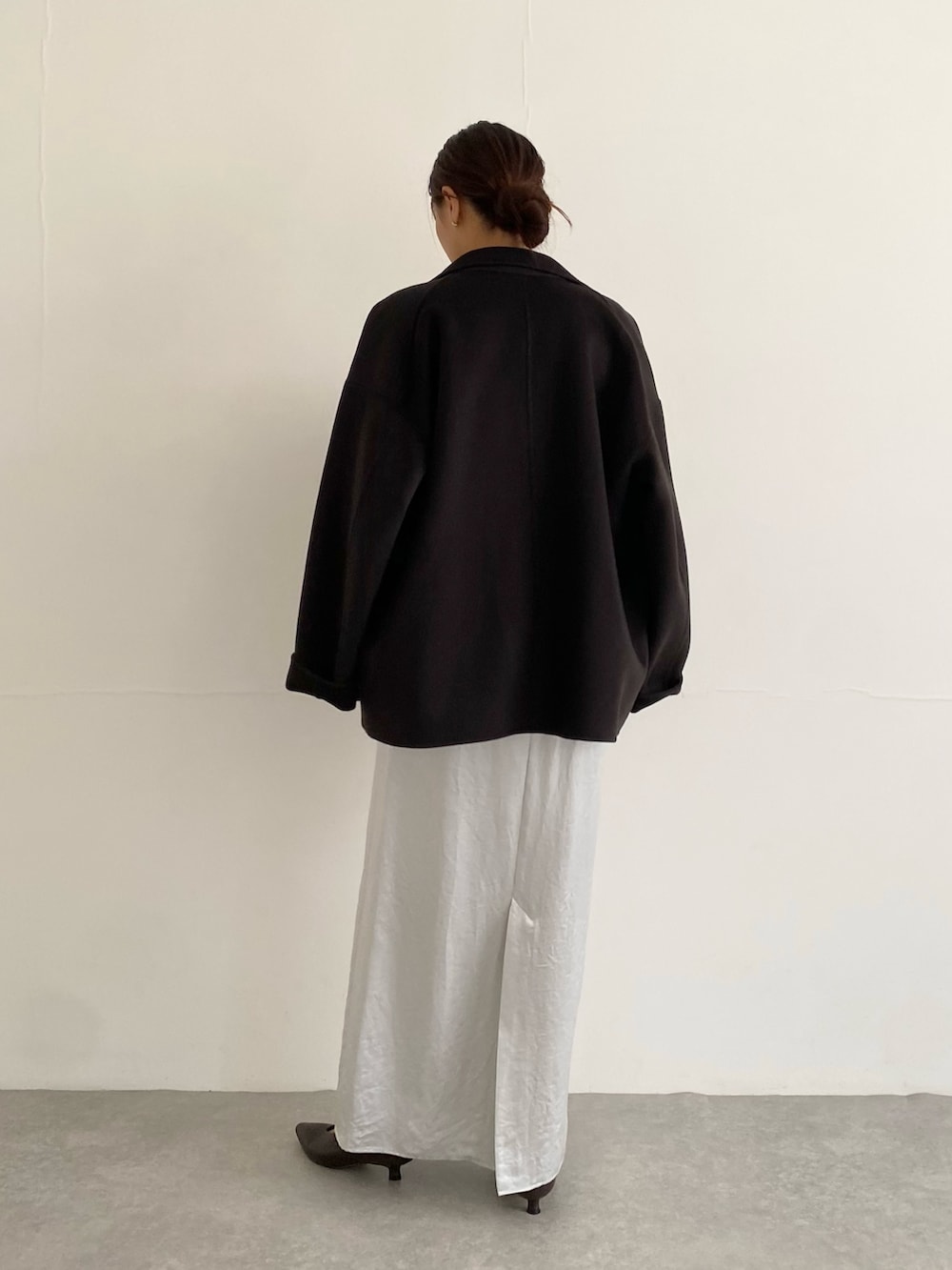 グレー系のその他アウター、ブラウン系のパンプス、ホワイト系のニット/セーターを着用したレディースの秋コーディネートの4枚目の写真