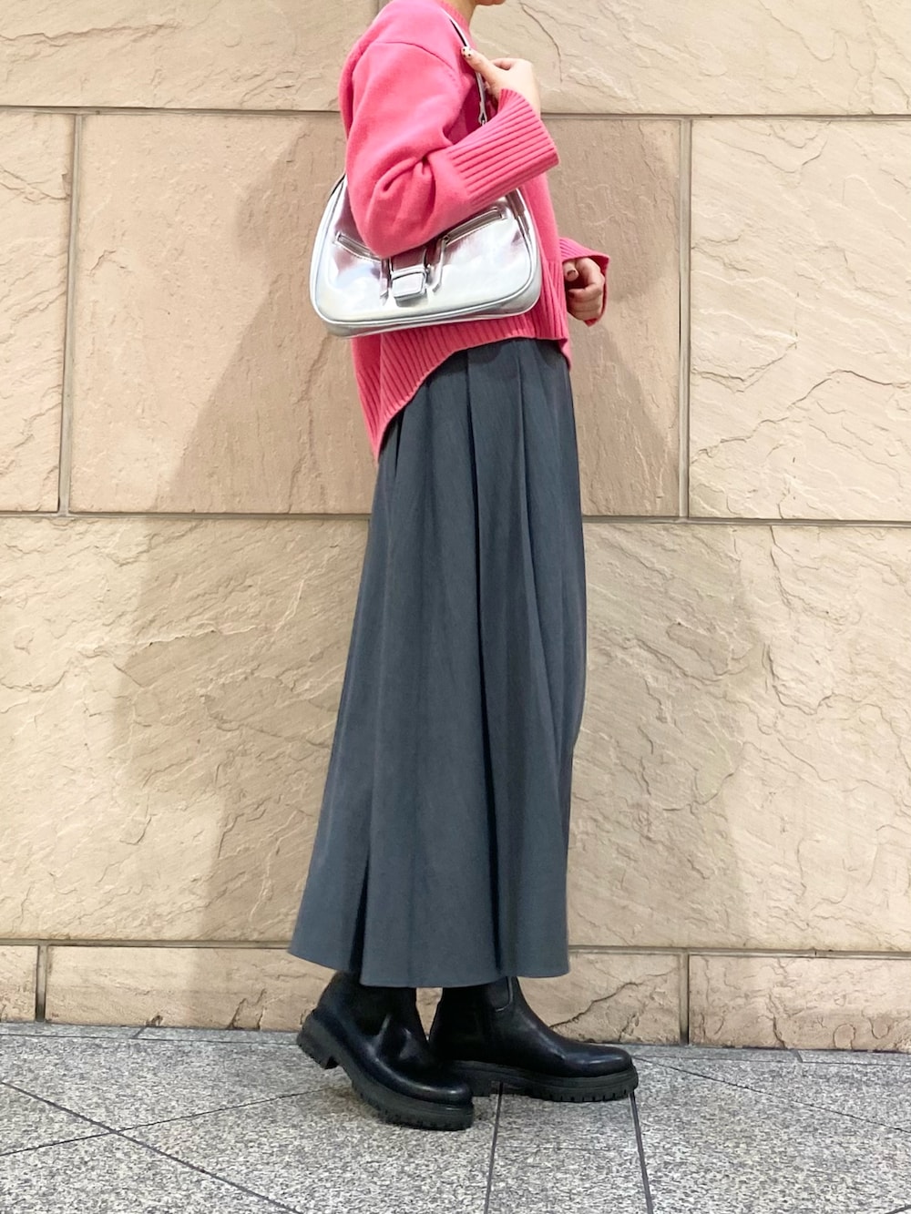 グレー系のスカート、ピンク系のニット/セーター、シルバー系のブローチ/コサージュを着用したレディースの冬コーディネートの7枚目の写真