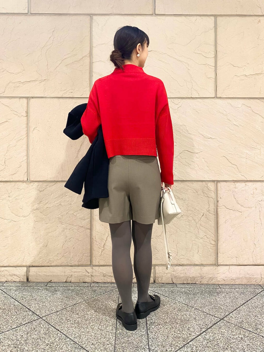 ブラック系のその他アウター、ブラウン系のスカート、レッド系のニット/セーターを着用したレディースの冬コーディネートの5枚目の写真