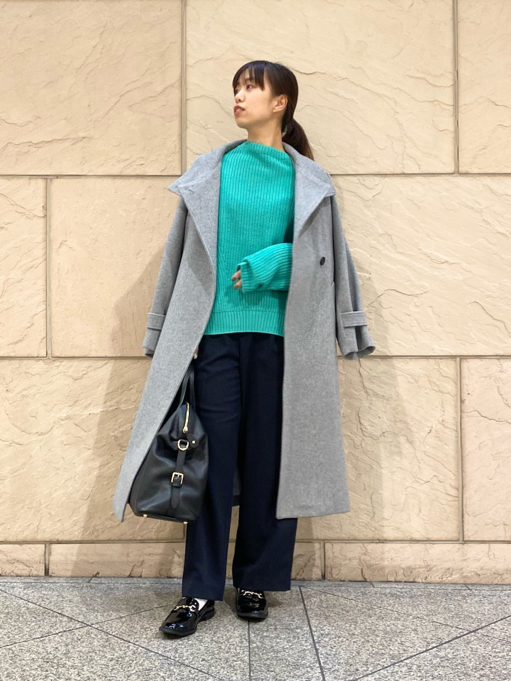 グレー系のその他アウター、グリーン系のニット/セーター、ブルー系のその他パンツを着用したレディースの冬コーディネートの2枚目の写真