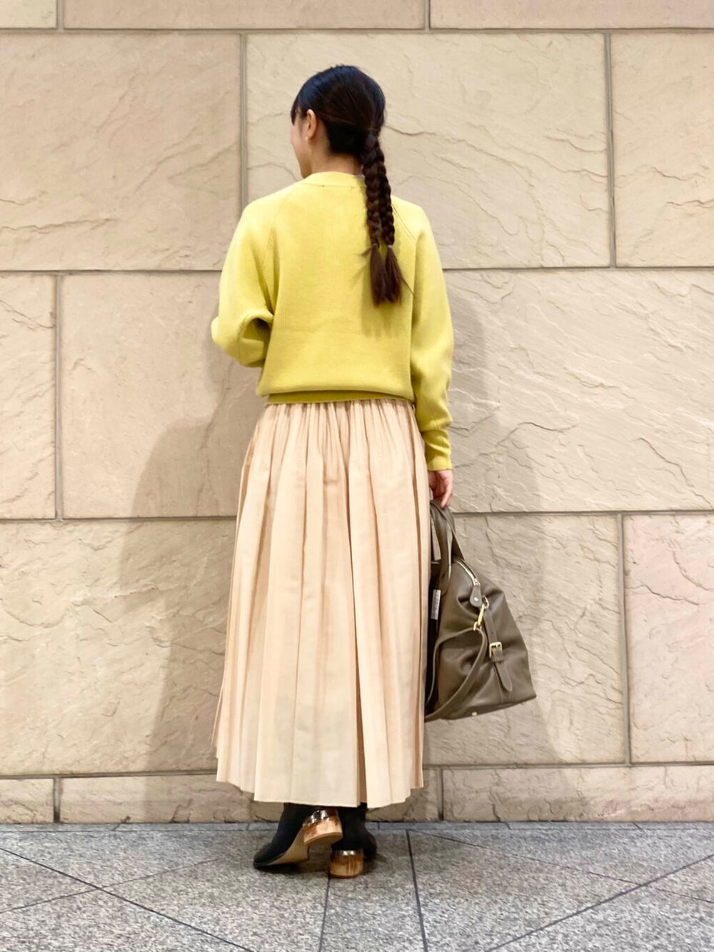 ベージュ系のボストンバッグ、イエロー系のスカート、イエロー系のカーディガン/ボレロを着用したレディースの冬コーディネートの5枚目の写真