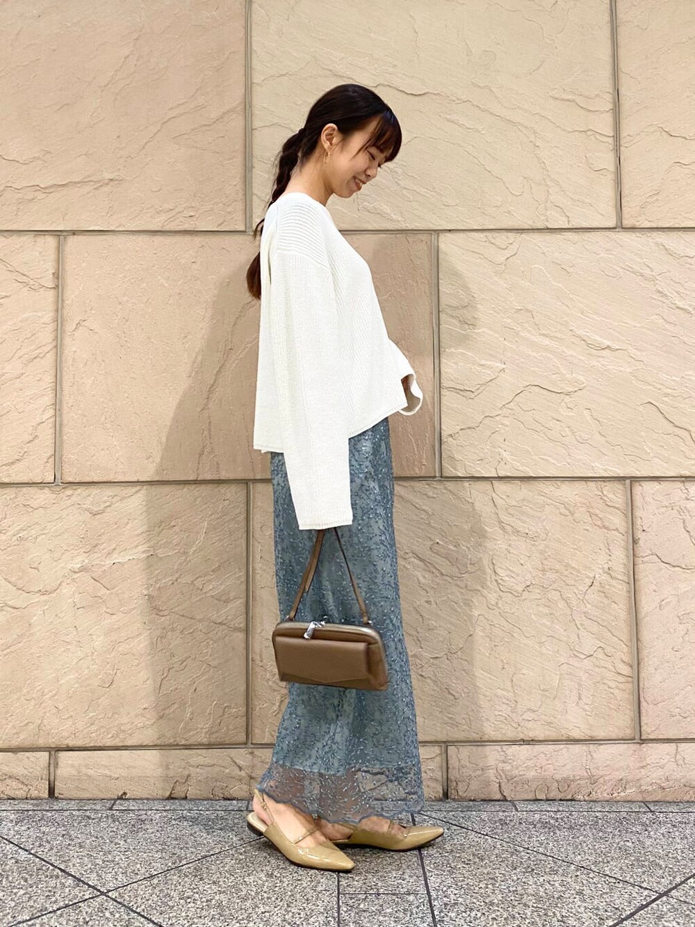 ベージュ系のパンプス、ブルー系のスカート、ホワイト系のニット/セーターを着用したレディースの冬コーディネートの3枚目の写真