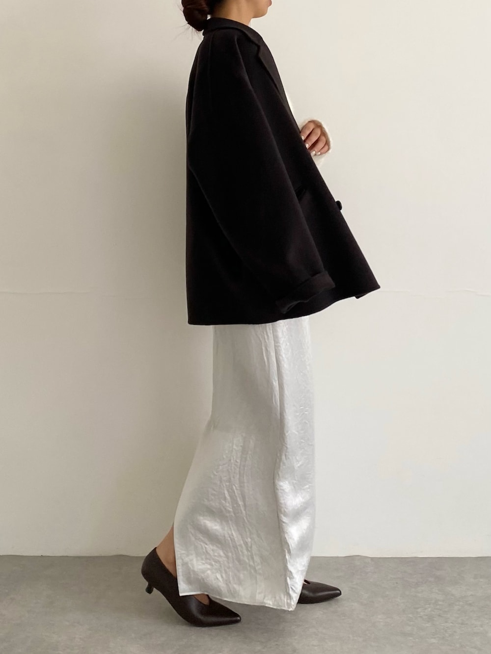 グレー系のその他アウター、ブラウン系のパンプス、ホワイト系のニット/セーターを着用したレディースの秋コーディネートの3枚目の写真