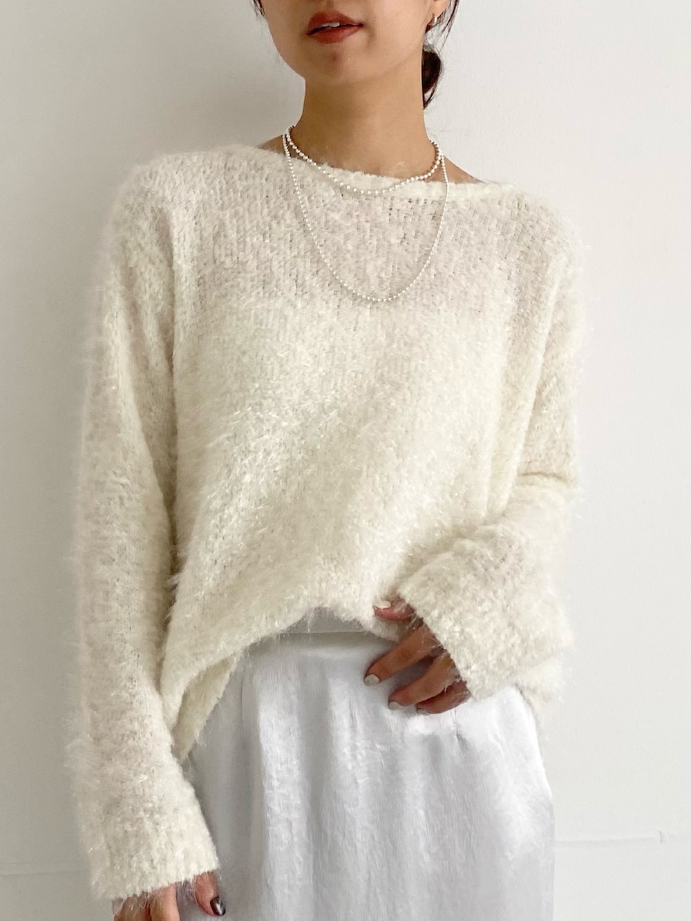 グレー系のその他アウター、ブラウン系のパンプス、ホワイト系のニット/セーターを着用したレディースの秋コーディネートの7枚目の写真