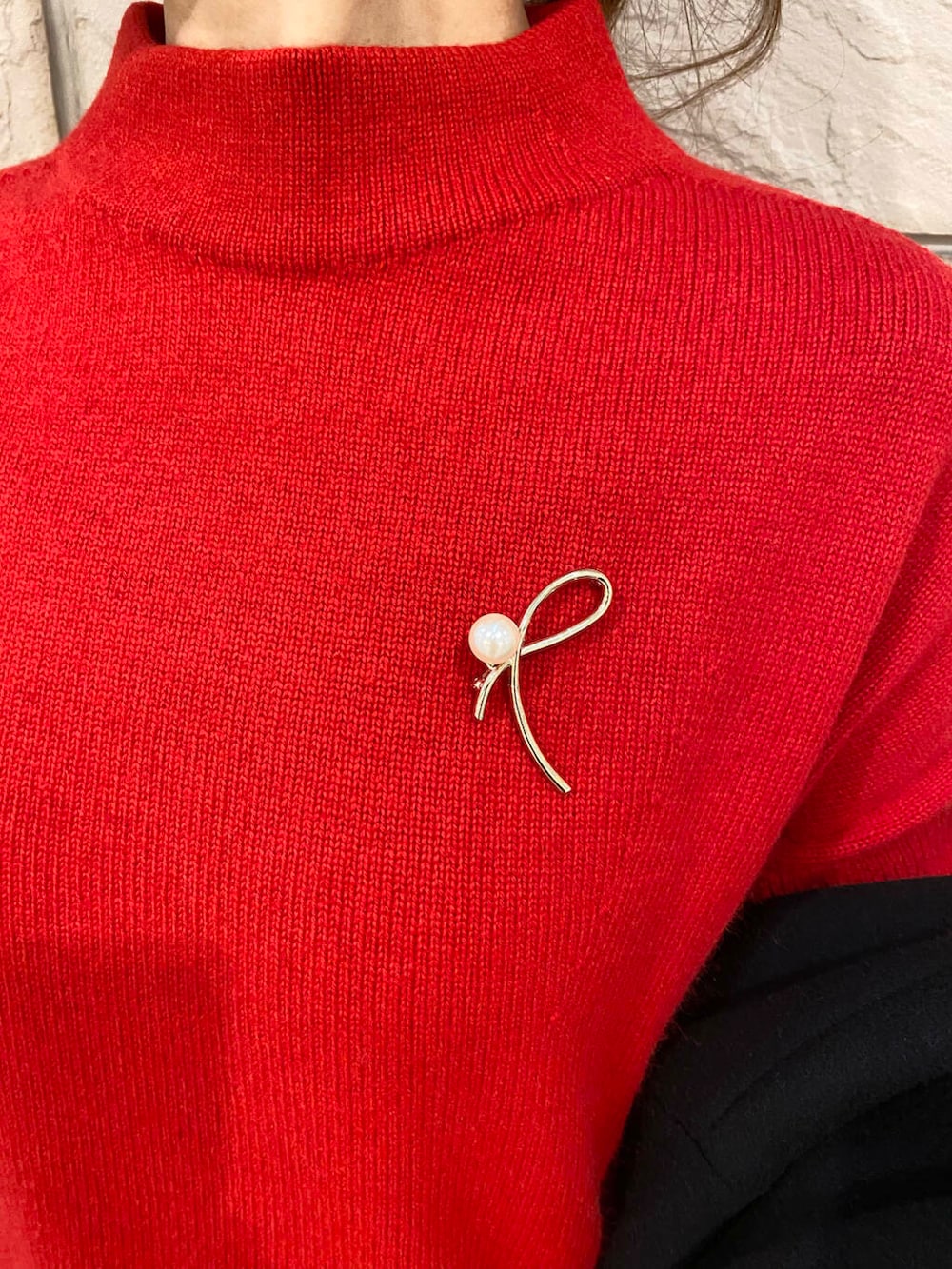 ブラック系のその他アウター、ブラウン系のスカート、レッド系のニット/セーターを着用したレディースの冬コーディネートの7枚目の写真