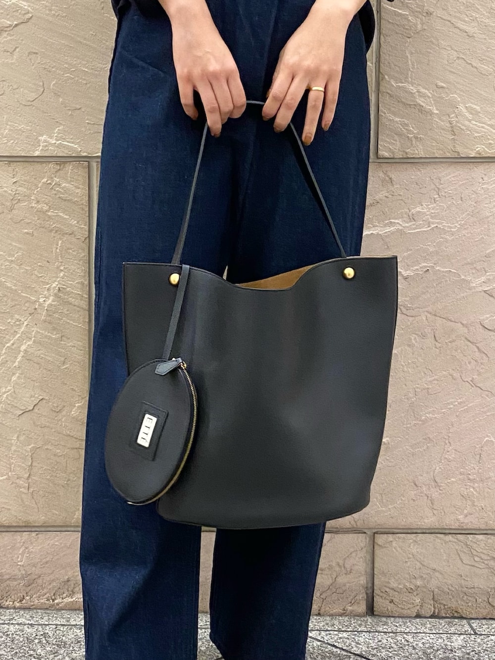 ブルー系のシャツ/ブラウス、ブラック系のトートバッグ、ブルー系のデニムパンツを着用したレディースの秋コーディネートの7枚目の写真