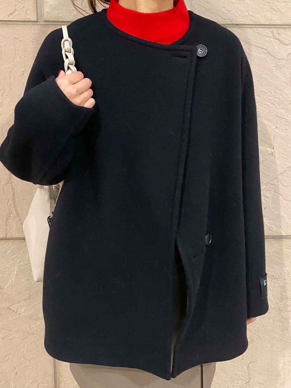 ブラック系のその他アウター、ブラウン系のスカート、レッド系のニット/セーターを着用したレディースの冬コーディネートの10枚目の写真