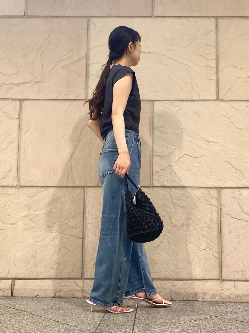 ブルー系のデニムパンツ、ブラック系のショルダーバッグ、グレー系のTシャツ/カットソーを着用したレディースの夏コーディネートの3枚目の写真