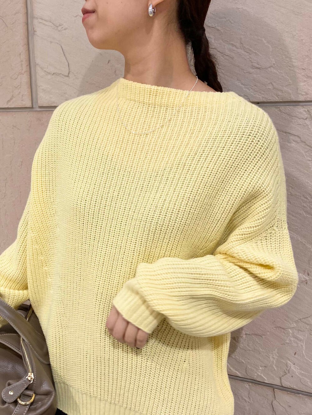 ベージュ系のボストンバッグ、グレー系のスカート、イエロー系のニット/セーターを着用したレディースの冬コーディネートの7枚目の写真