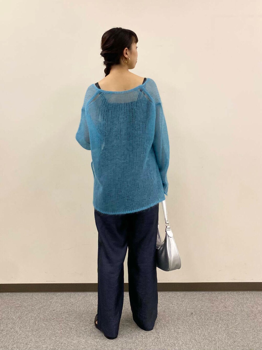 ブルー系のニット/セーター、グレー系のその他パンツ、シルバー系のハンドバッグを着用したレディースの夏コーディネートの4枚目の写真
