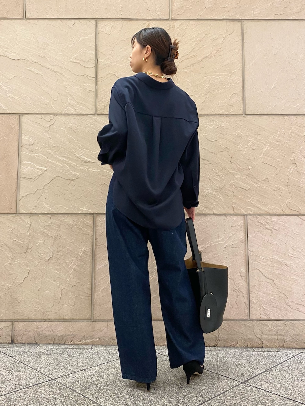 ブルー系のシャツ/ブラウス、ブラック系のトートバッグ、ブルー系のデニムパンツを着用したレディースの秋コーディネートの4枚目の写真