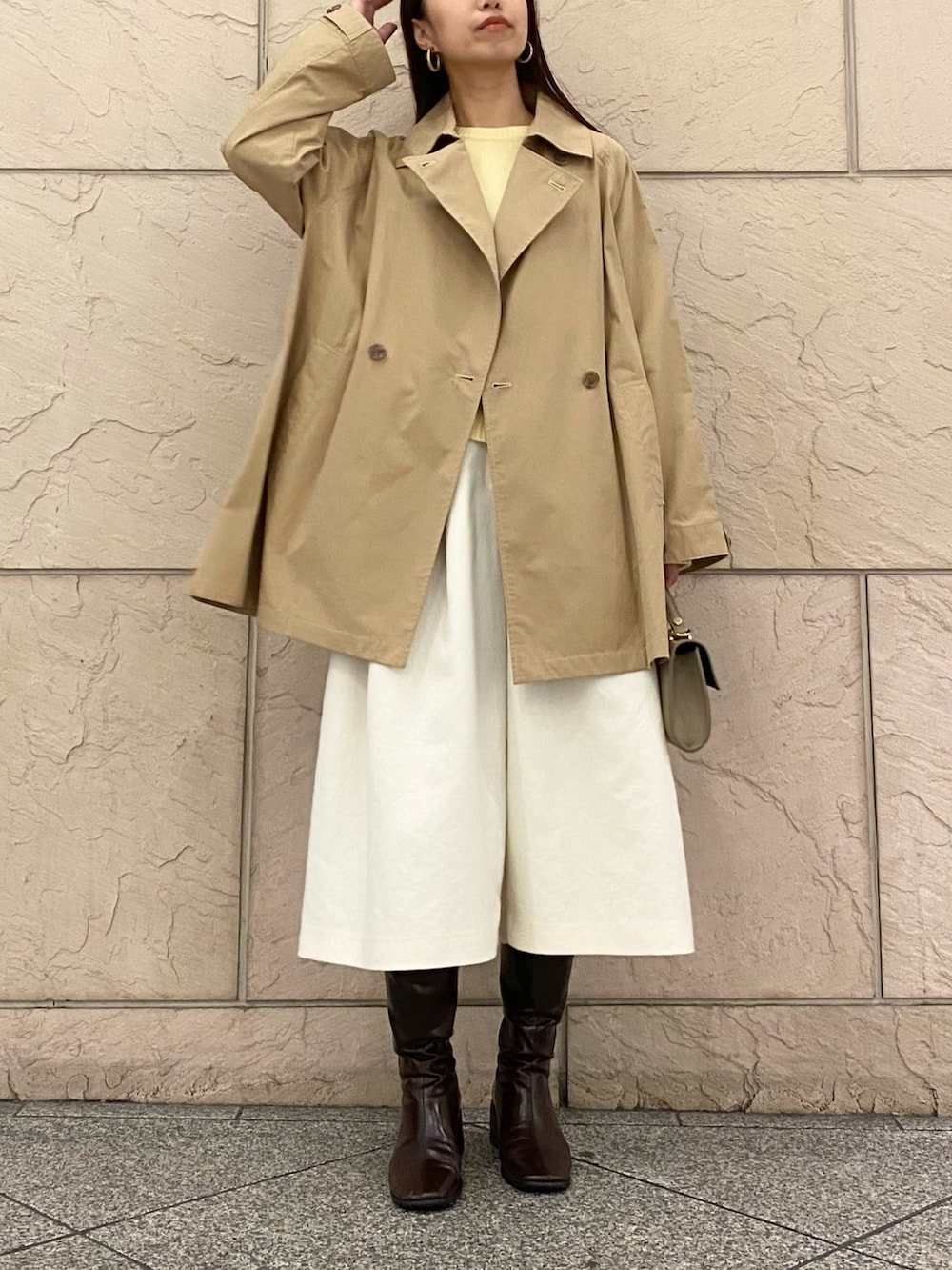 イエロー系のニット/セーター、イエロー系のニット/セーター、ベージュ系のその他アウターを着用したレディースの秋コーディネートの2枚目の写真