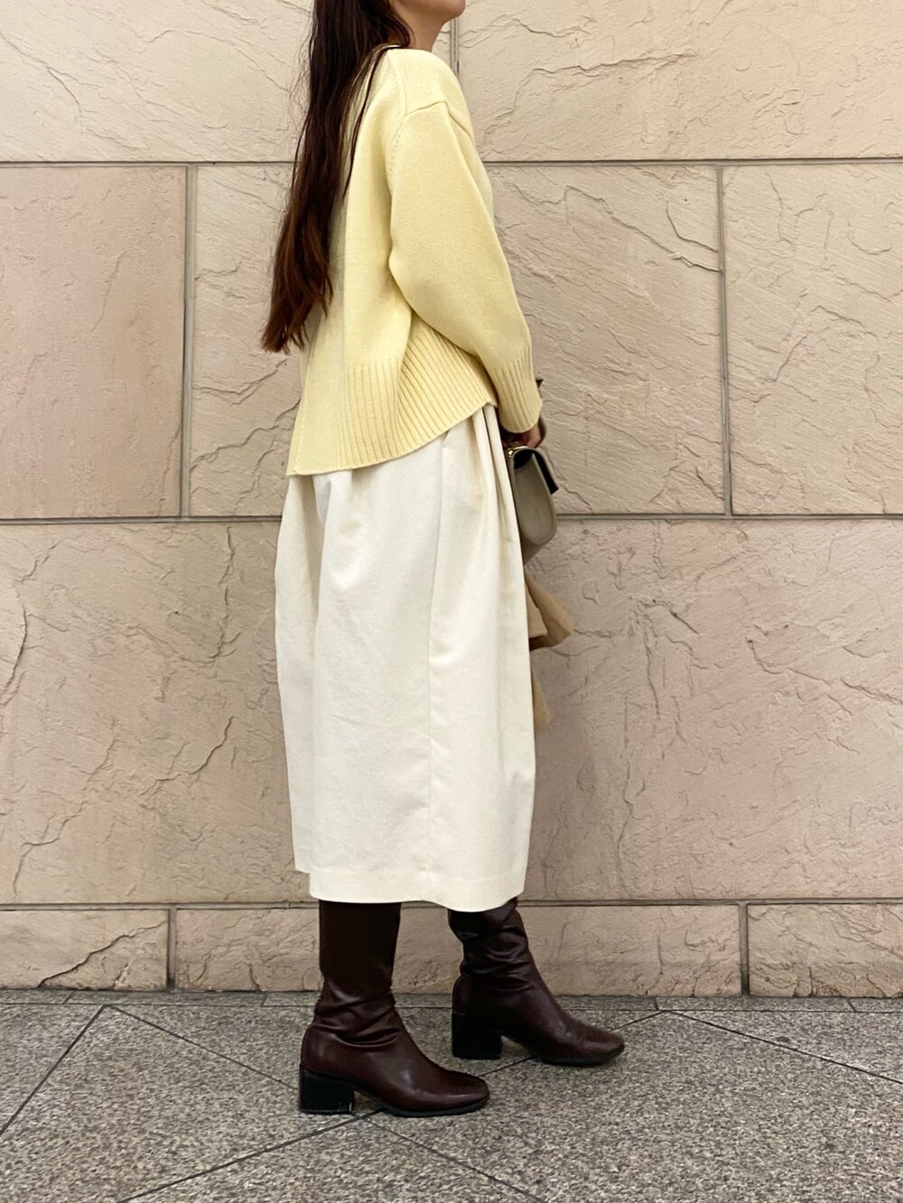 イエロー系のニット/セーター、イエロー系のニット/セーター、ベージュ系のその他アウターを着用したレディースの秋コーディネートの6枚目の写真