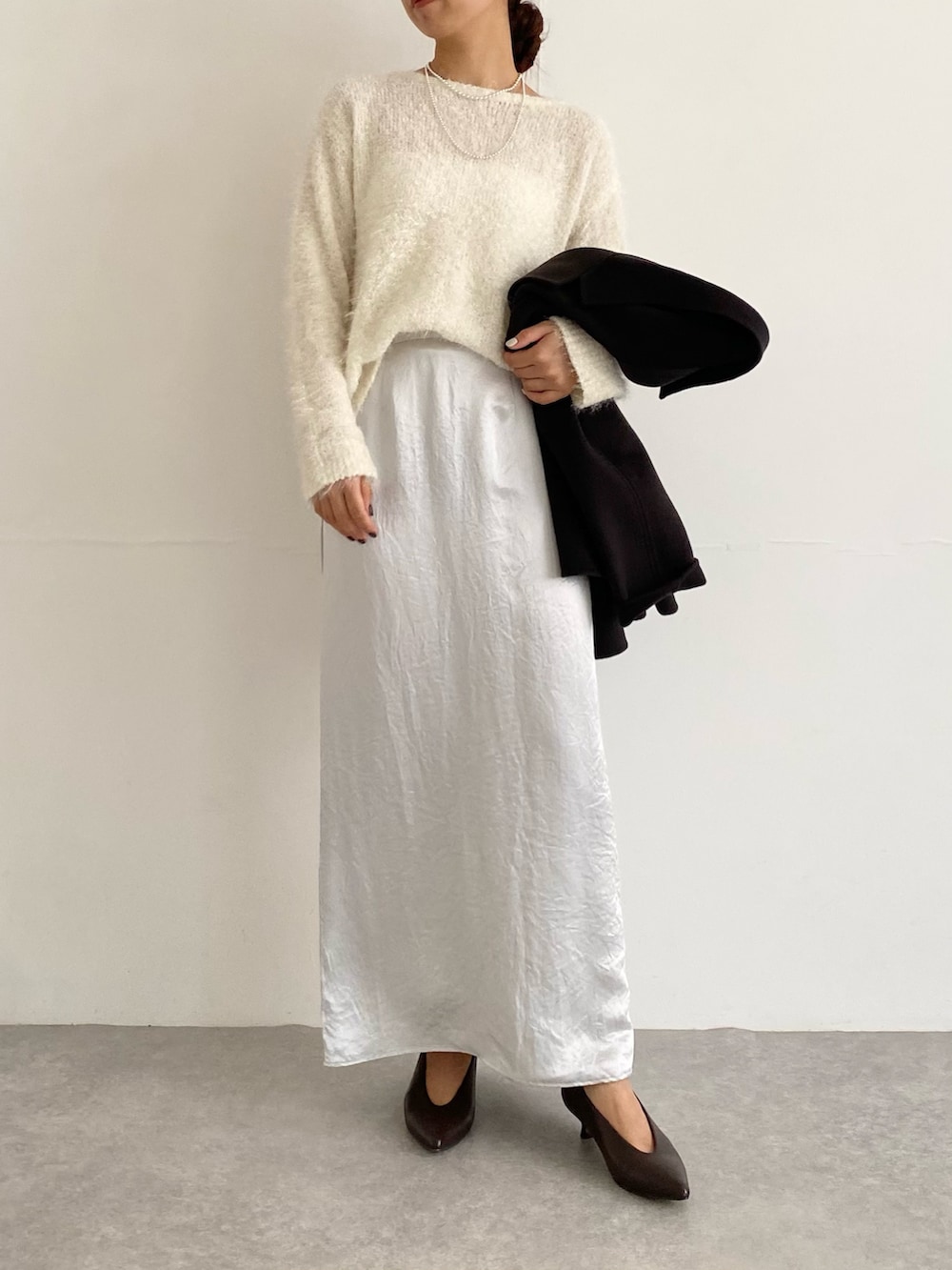 グレー系のその他アウター、ブラウン系のパンプス、ホワイト系のニット/セーターを着用したレディースの秋コーディネートの6枚目の写真