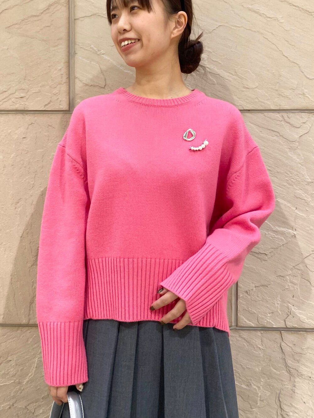 ピンク系のニット/セーター、ブラック系のブーツ、グレー系のスカートを着用したレディースの冬コーディネートの8枚目の写真