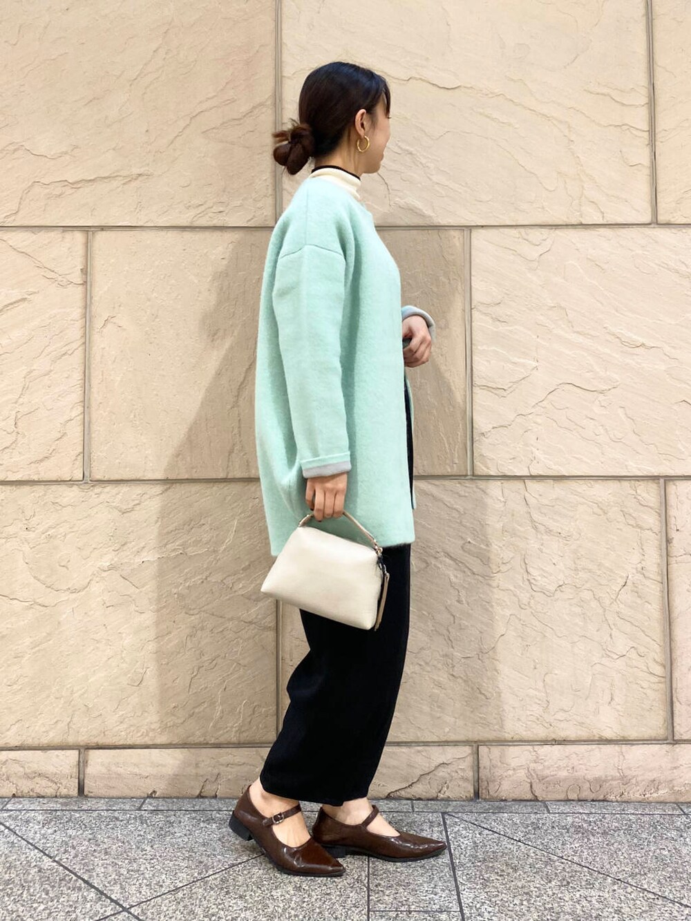 ブラック系のその他パンツ、ホワイト系のニット/セーター、グリーン系のカーディガン/ボレロを着用したレディースの秋コーディネートの5枚目の写真