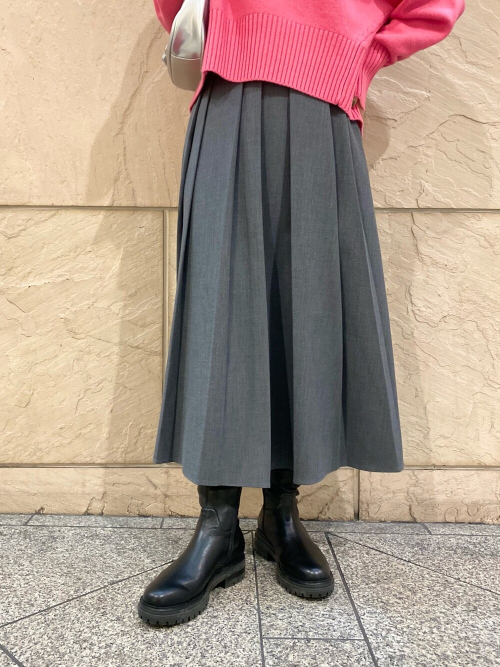 グレー系のスカート、ピンク系のニット/セーター、シルバー系のブローチ/コサージュを着用したレディースの冬コーディネートの9枚目の写真