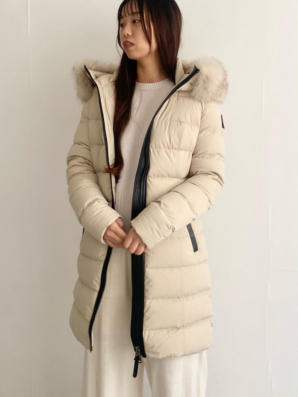 ベージュ系のその他アウター、ホワイト系のニット/セーター、ホワイト系のその他パンツを着用したレディースの秋コーディネートの6枚目の写真