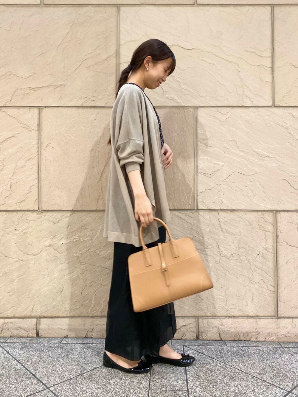 ブラック系のその他パンツ、イエロー系のトートバッグ、ベージュ系のカーディガン/ボレロを着用したレディースの春コーディネートの3枚目の写真