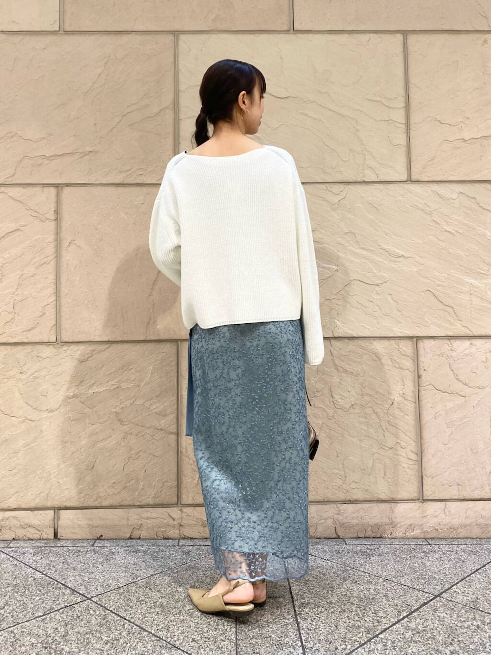 ベージュ系のパンプス、ブルー系のスカート、ホワイト系のニット/セーターを着用したレディースの冬コーディネートの4枚目の写真