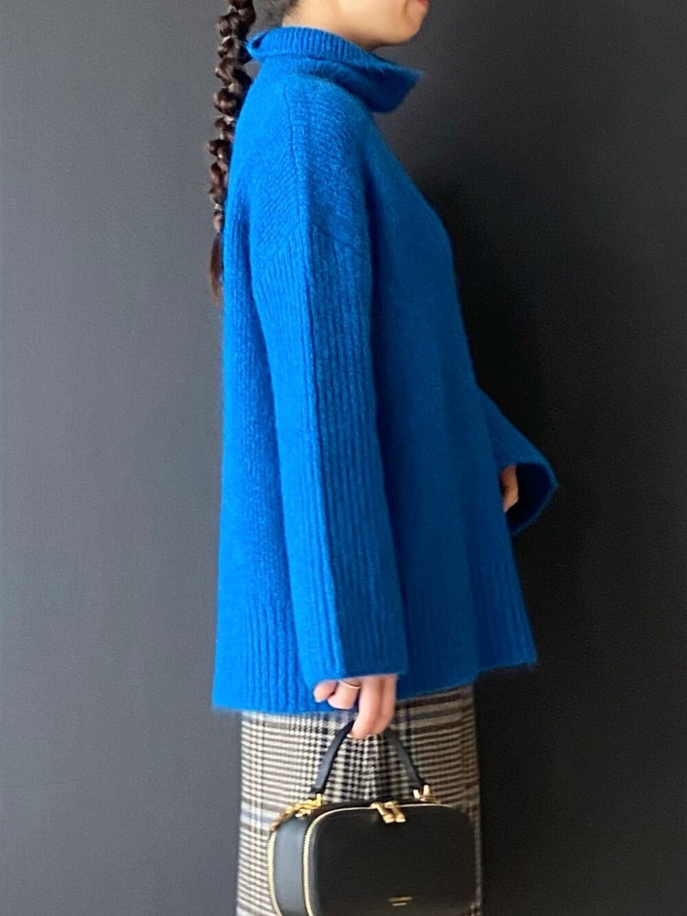 ブルー系のニット/セーター、ブルー系のスカート、ブラック系のショルダーバッグを着用したレディースの冬コーディネートの3枚目の写真