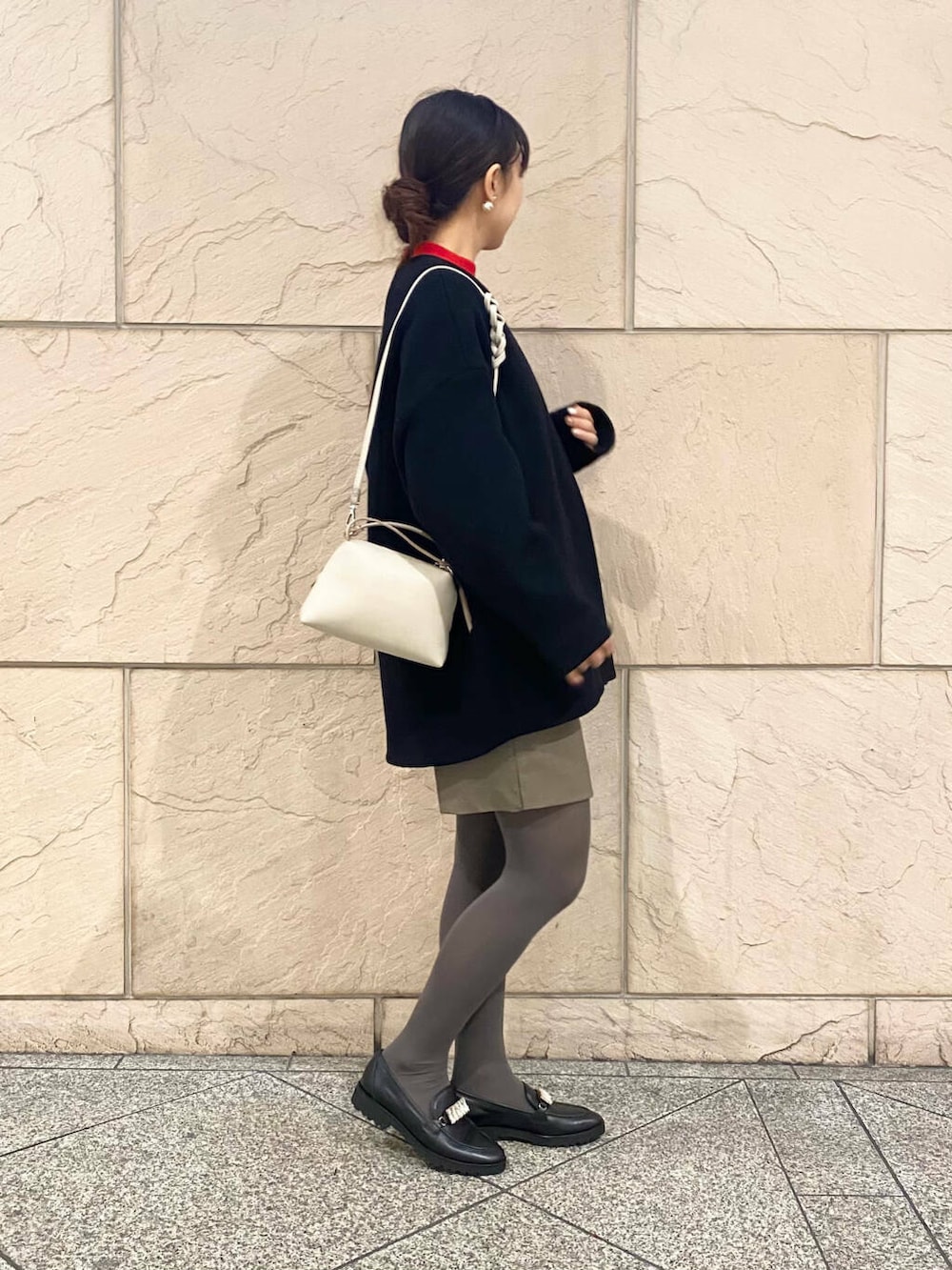 ブラック系のその他アウター、ブラウン系のスカート、レッド系のニット/セーターを着用したレディースの冬コーディネートの2枚目の写真