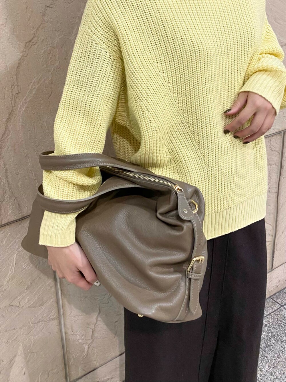 ベージュ系のボストンバッグ、グレー系のスカート、イエロー系のニット/セーターを着用したレディースの冬コーディネートの6枚目の写真