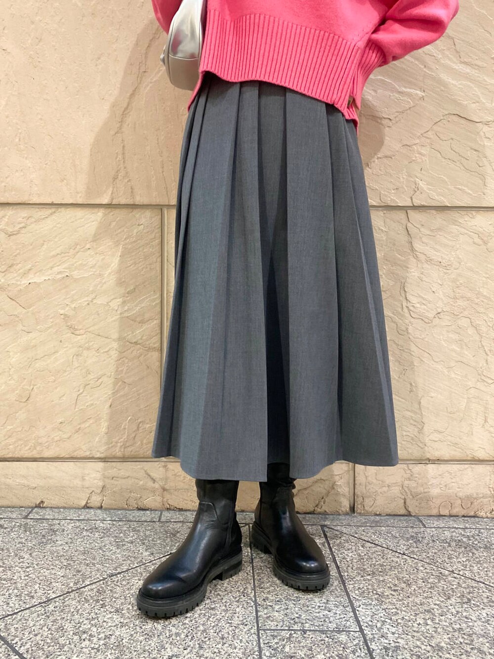 ピンク系のニット/セーター、ブラック系のブーツ、グレー系のスカートを着用したレディースの冬コーディネートの9枚目の写真