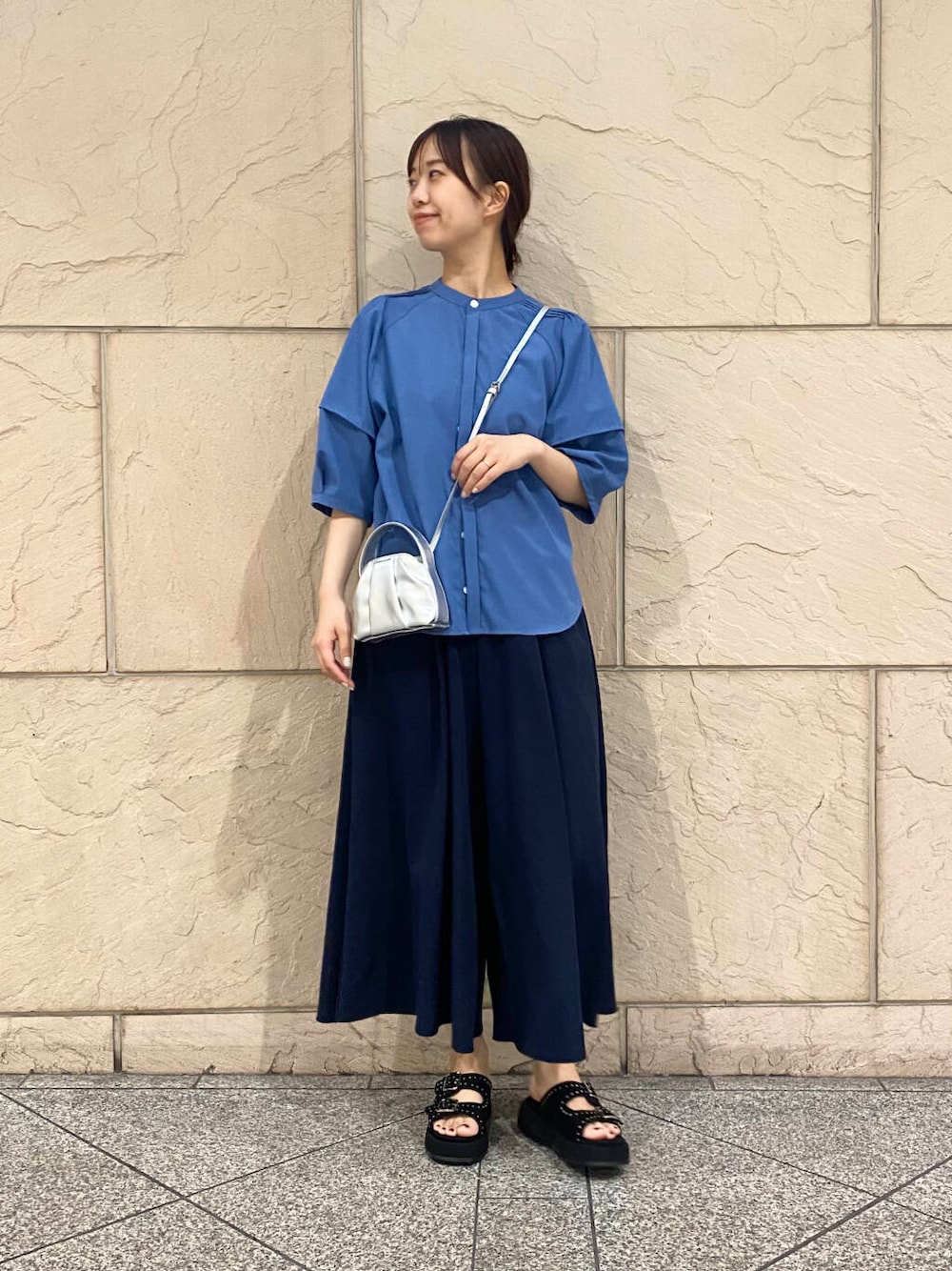 シルバー系のハンドバッグ、ブルー系のその他パンツ、ブルー系のシャツ/ブラウスを着用したレディースの夏コーディネートの2枚目の写真