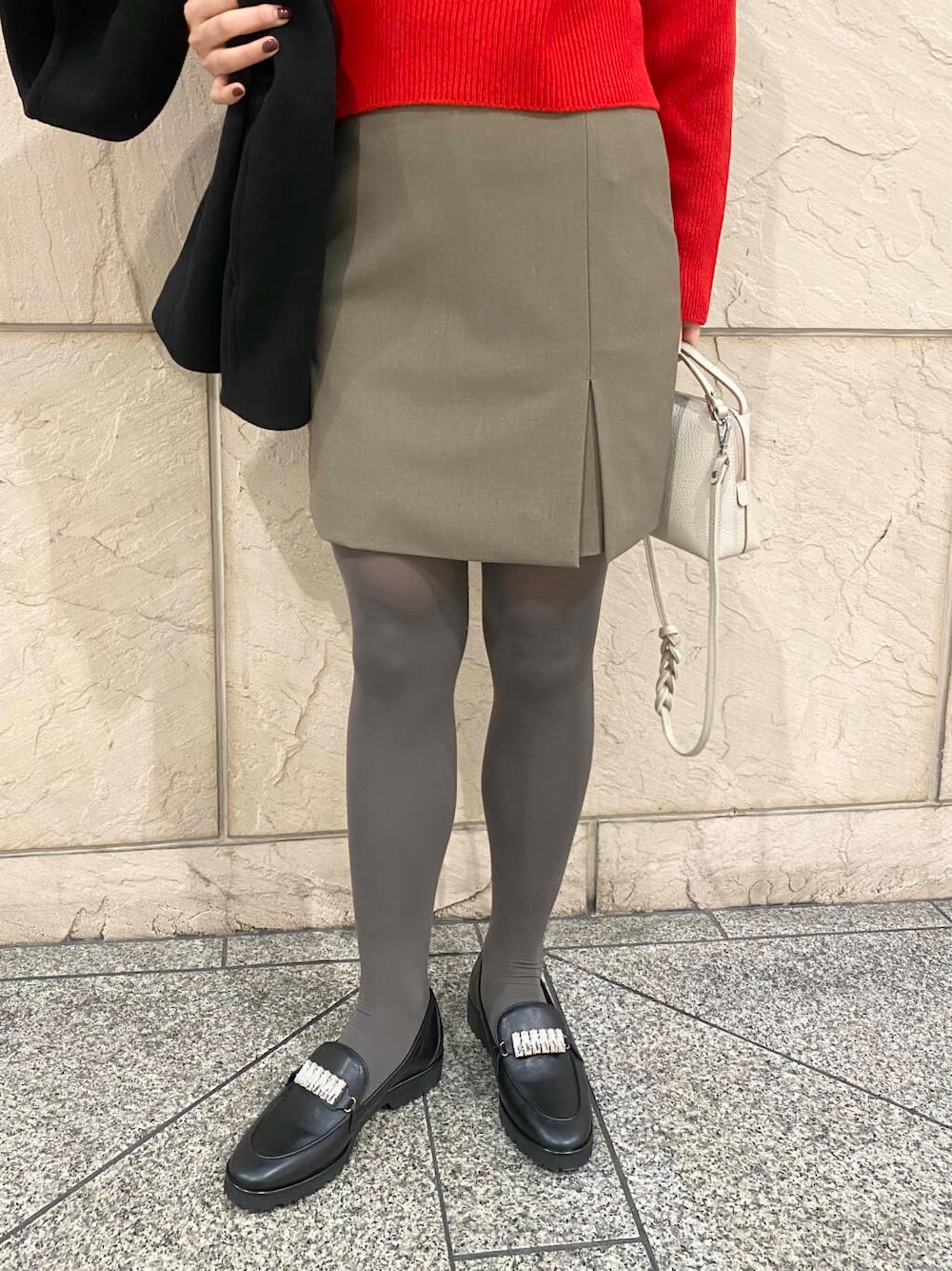 ブラック系のその他アウター、ブラウン系のスカート、レッド系のニット/セーターを着用したレディースの冬コーディネートの8枚目の写真