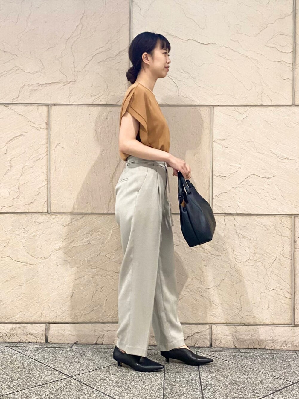 ベージュ系のその他パンツ、イエロー系のシャツ/ブラウス、ブラック系のパンプスを着用したレディースの夏コーディネートの3枚目の写真
