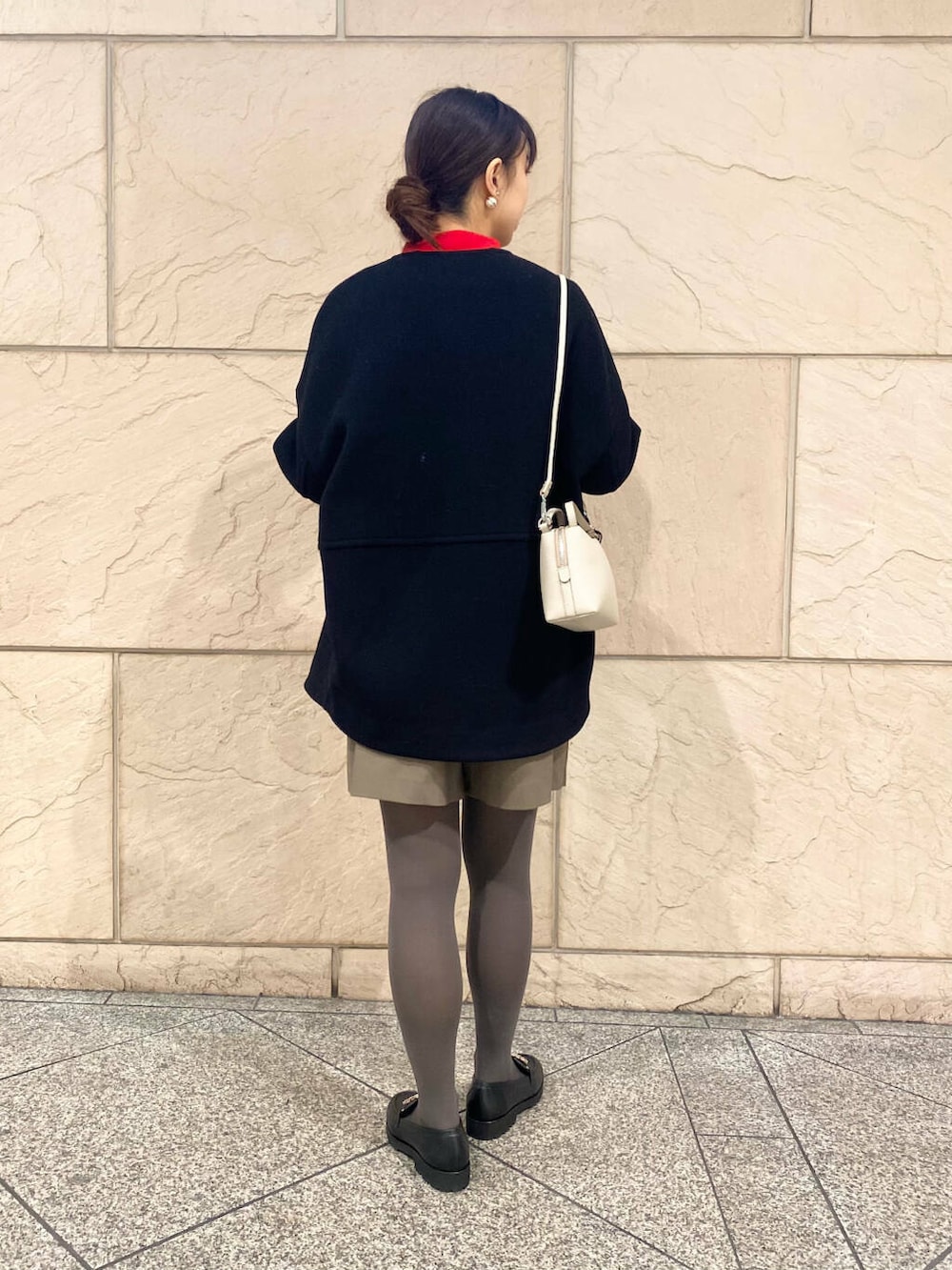 ブラック系のその他アウター、ブラウン系のスカート、レッド系のニット/セーターを着用したレディースの冬コーディネートの3枚目の写真