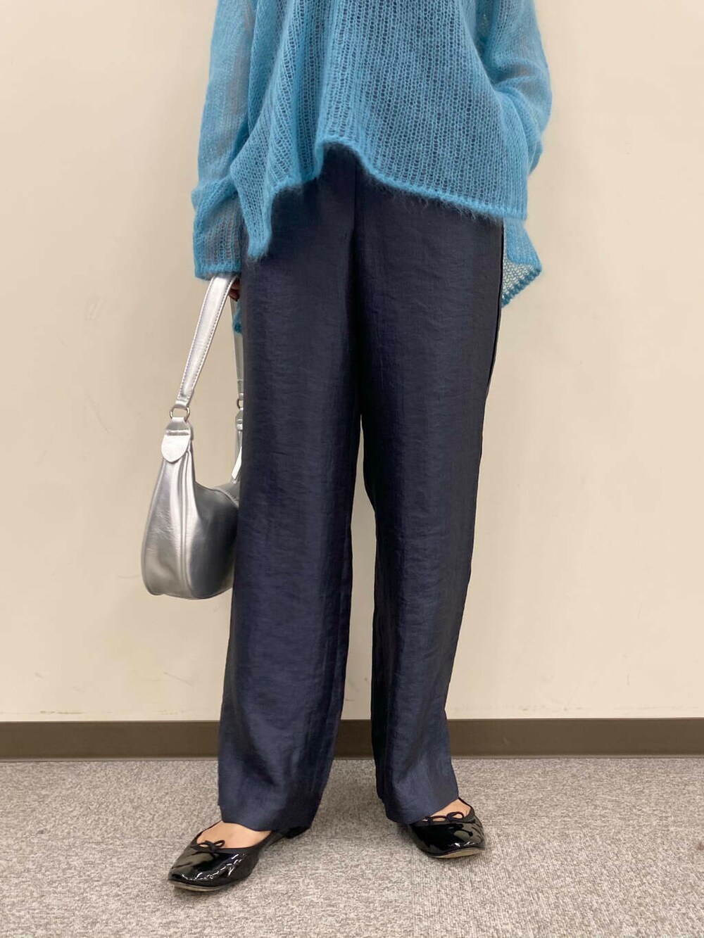 ブルー系のニット/セーター、グレー系のその他パンツ、シルバー系のハンドバッグを着用したレディースの夏コーディネートの7枚目の写真