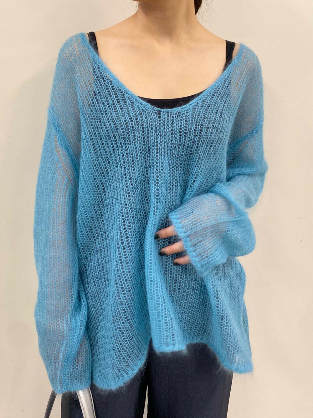 ブルー系のニット/セーター、グレー系のその他パンツ、シルバー系のハンドバッグを着用したレディースの夏コーディネートの5枚目の写真