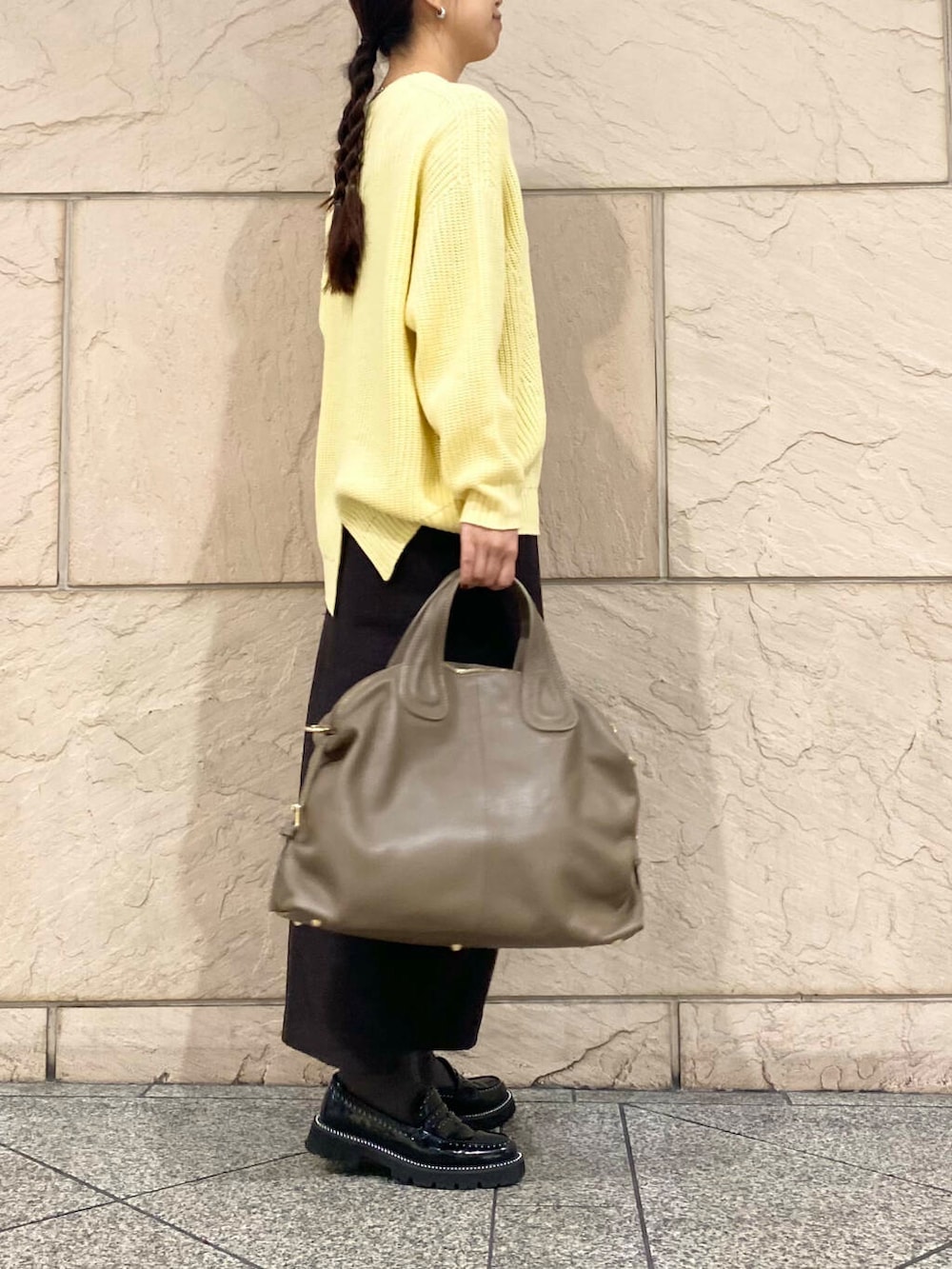ベージュ系のボストンバッグ、グレー系のスカート、イエロー系のニット/セーターを着用したレディースの冬コーディネートの3枚目の写真