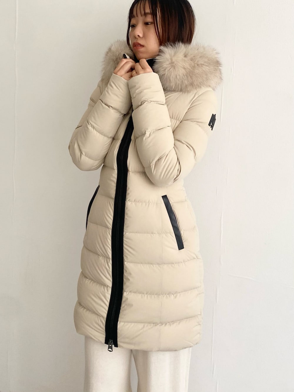 ベージュ系のその他アウター、ホワイト系のニット/セーター、ホワイト系のその他パンツを着用したレディースの秋コーディネートの9枚目の写真