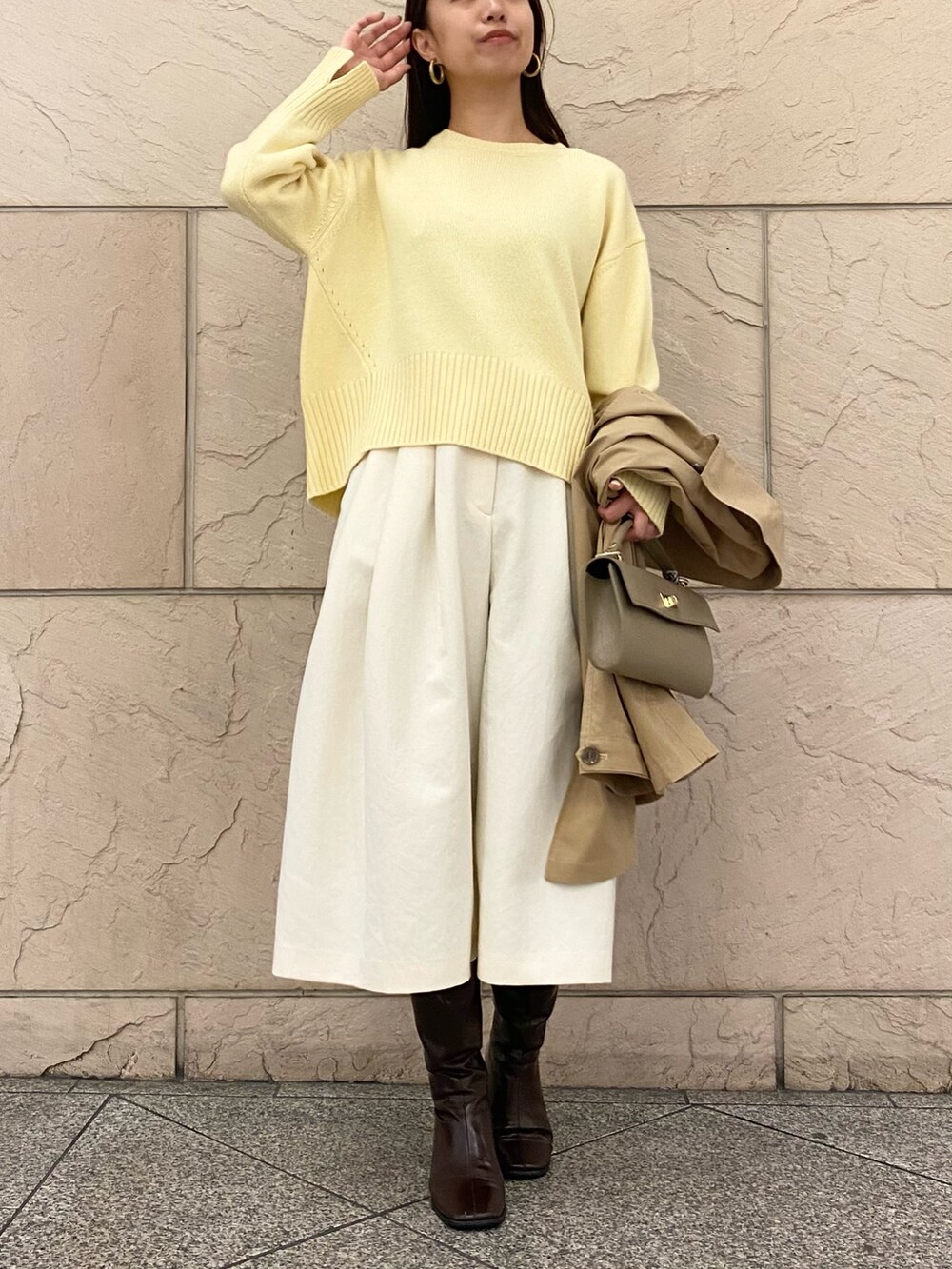 イエロー系のニット/セーター、イエロー系のニット/セーター、ベージュ系のその他アウターを着用したレディースの秋コーディネートの5枚目の写真