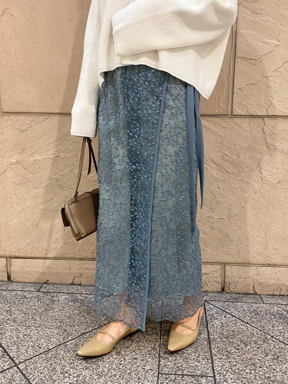 ベージュ系のパンプス、ブルー系のスカート、ホワイト系のニット/セーターを着用したレディースの冬コーディネートの6枚目の写真