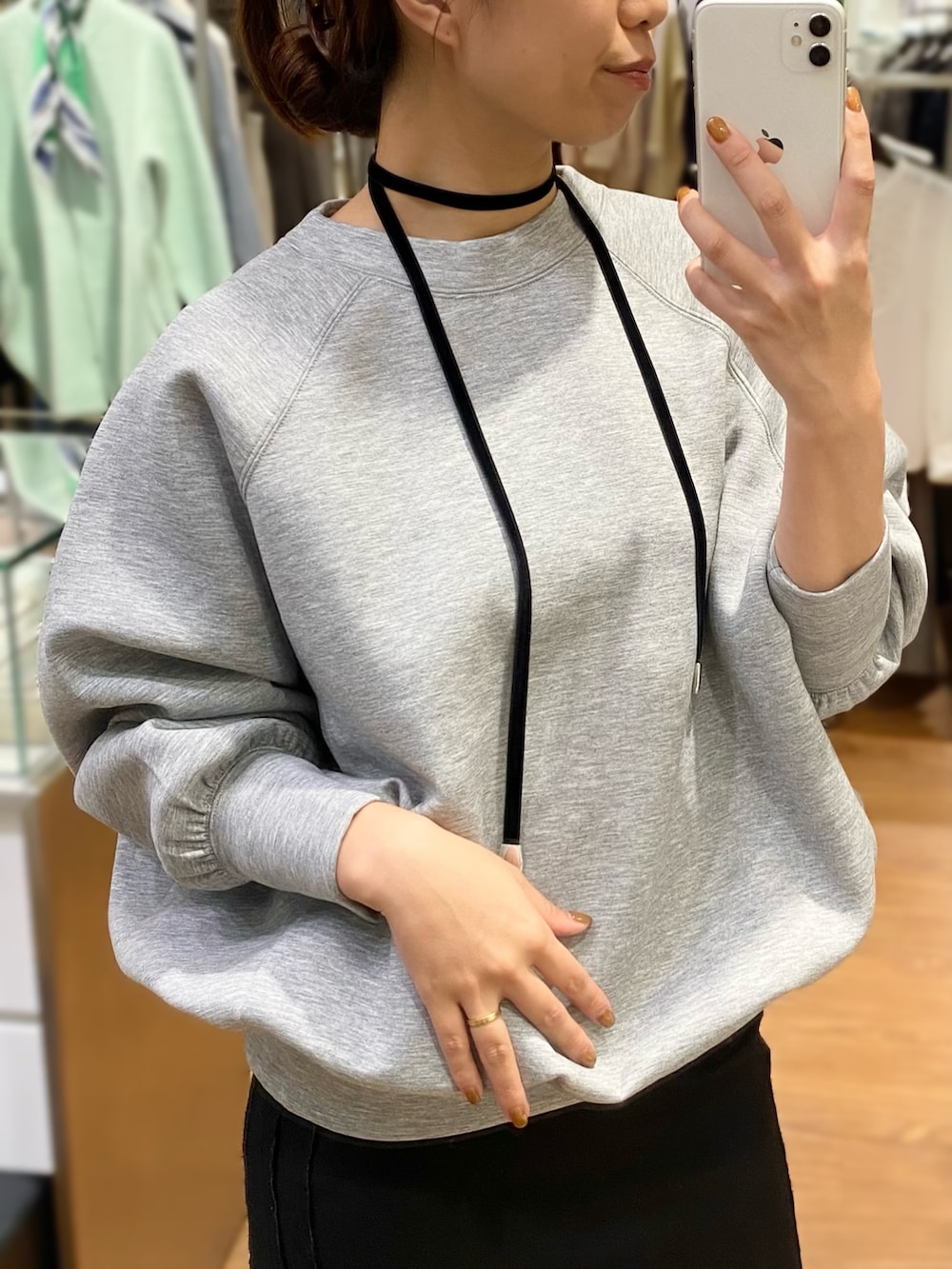 レッド系のブーツ、グレー系のスウェット、ブラック系のネックレスを着用したレディースの秋コーディネートの2枚目の写真