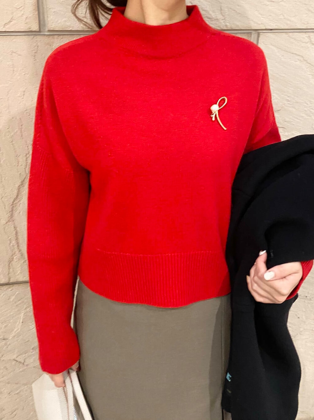 ブラック系のその他アウター、ブラウン系のスカート、レッド系のニット/セーターを着用したレディースの冬コーディネートの6枚目の写真