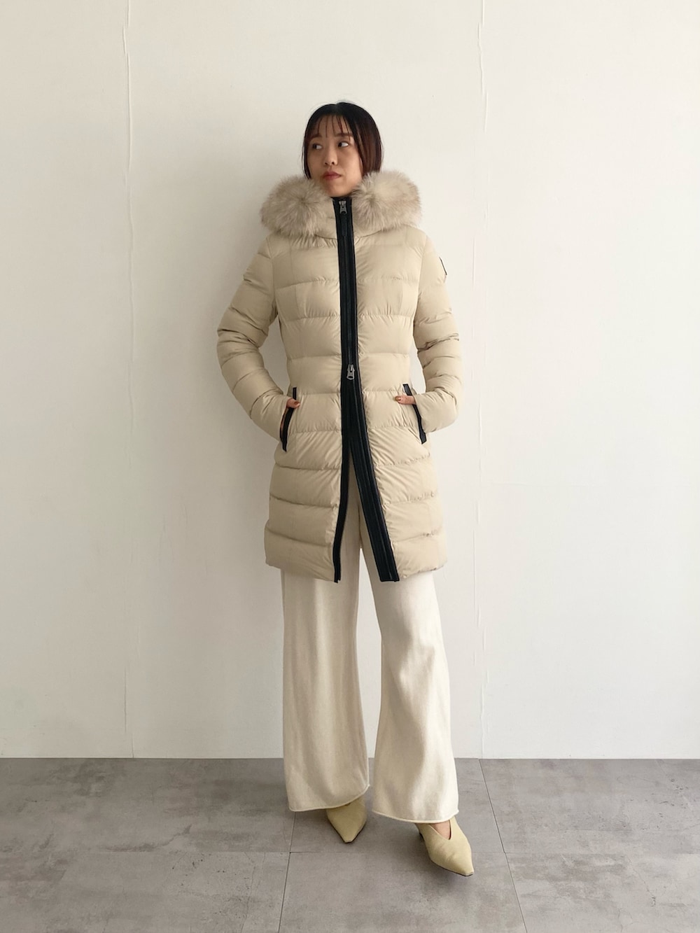 ベージュ系のその他アウター、ホワイト系のニット/セーター、ホワイト系のその他パンツを着用したレディースの秋コーディネートの4枚目の写真