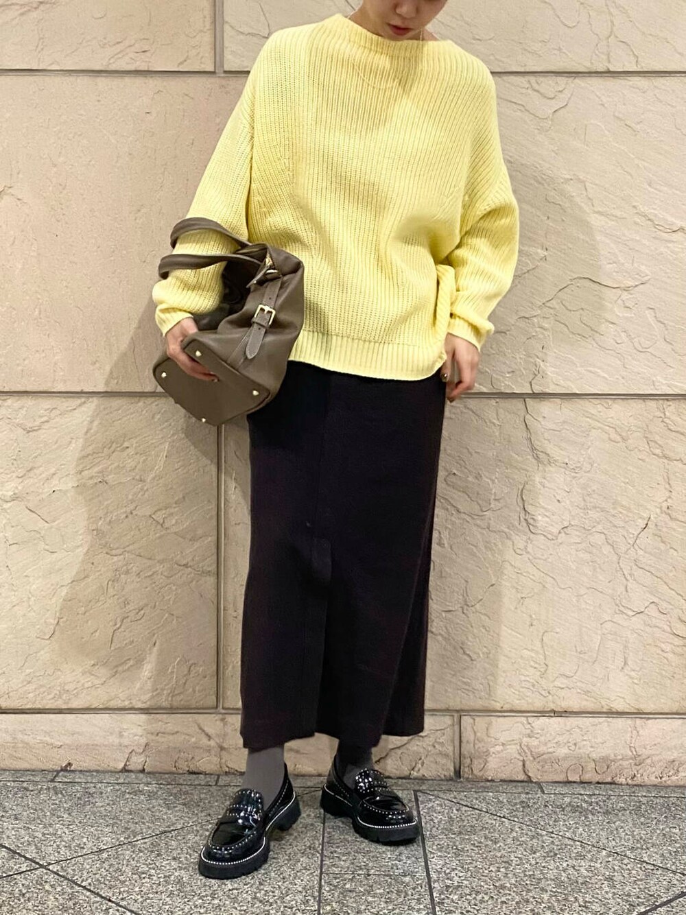 ベージュ系のボストンバッグ、グレー系のスカート、イエロー系のニット/セーターを着用したレディースの冬コーディネートの5枚目の写真
