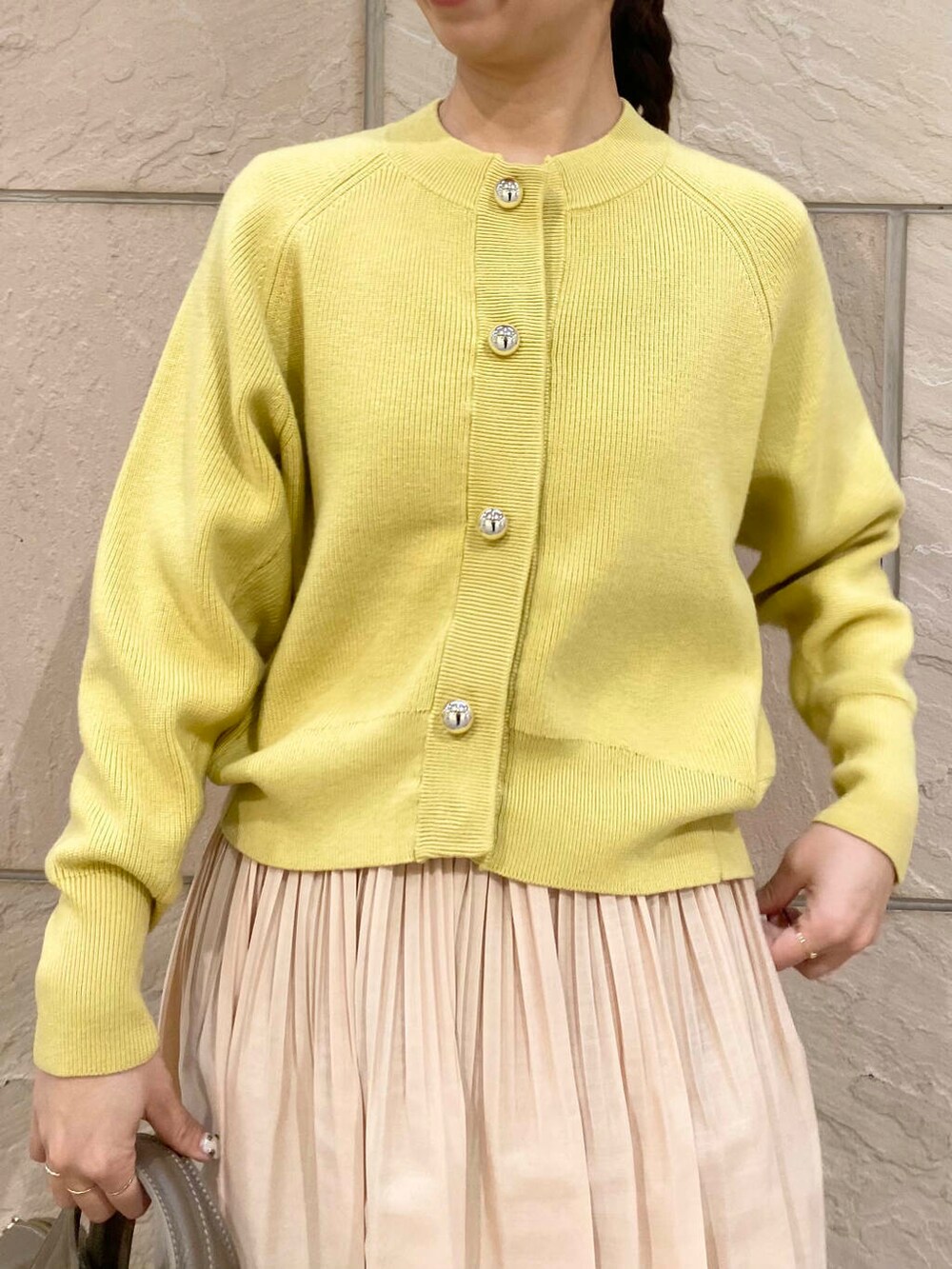 ベージュ系のボストンバッグ、イエロー系のスカート、イエロー系のカーディガン/ボレロを着用したレディースの冬コーディネートの6枚目の写真