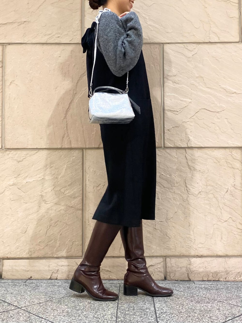 レッド系のブーツ、ブラック系のワンピース、グレー系のニット/セーターを着用したレディースの冬コーディネートの3枚目の写真