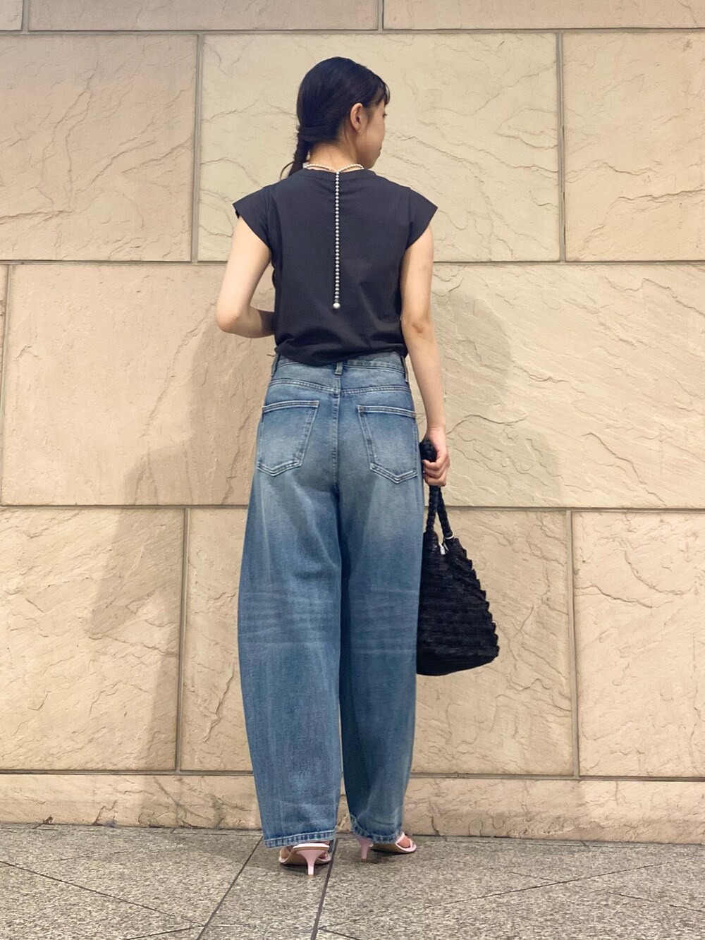 ブルー系のデニムパンツ、ブラック系のショルダーバッグ、グレー系のTシャツ/カットソーを着用したレディースの夏コーディネートの4枚目の写真