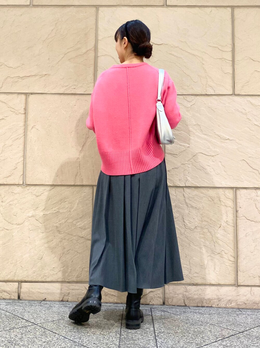 ピンク系のニット/セーター、ブラック系のブーツ、グレー系のスカートを着用したレディースの冬コーディネートの7枚目の写真