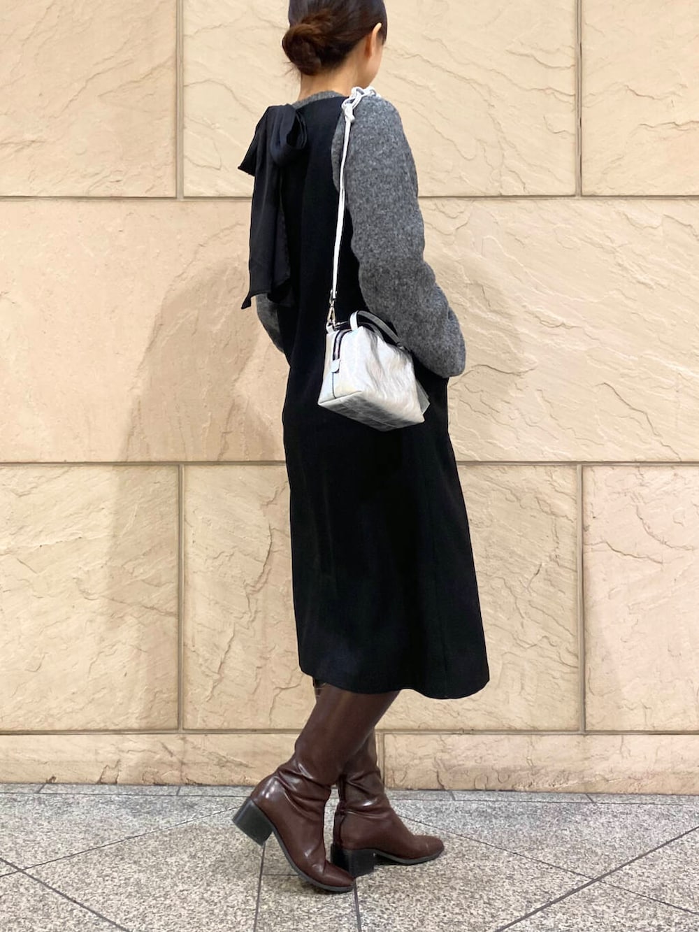 レッド系のブーツ、ブラック系のワンピース、グレー系のニット/セーターを着用したレディースの冬コーディネートの4枚目の写真